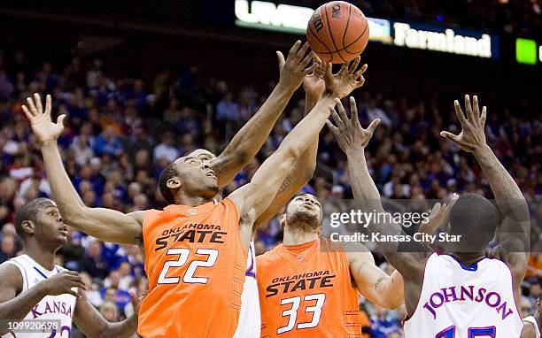 Oklahoma State guard Markel Brown , Kansas forward Marcus Morris , Oklahoma State forward Marshall Moses and Kansas guard Elijah Johnson battle for a...