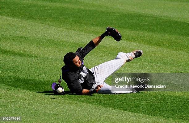 Willy Taveras Colorado Rockies is unable to catch a hit by Rickie Weeks of the Milwaukee Brewers at Maryvale Baseball Park on March 10, 2011 in...