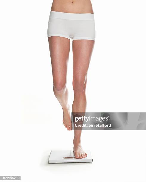 woman standing on scale with one foot - female legs studio shot stock pictures, royalty-free photos & images