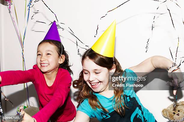 girls celebrating at party - party popper stock pictures, royalty-free photos & images