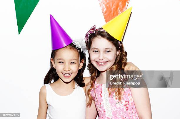 portrait of two girls at birthday party - party hat stock pictures, royalty-free photos & images