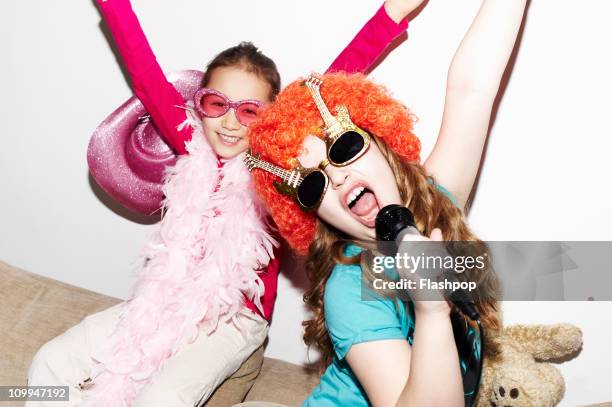 girls singing into microphones at party - fashion kids stock pictures, royalty-free photos & images