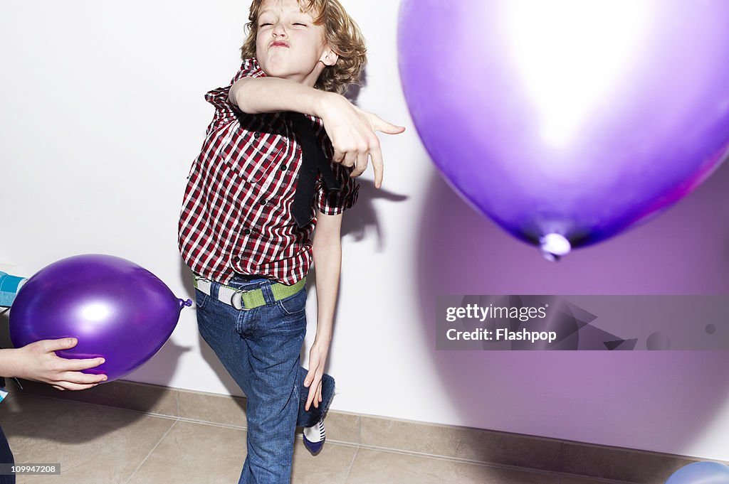 Boy playing with balloons at party