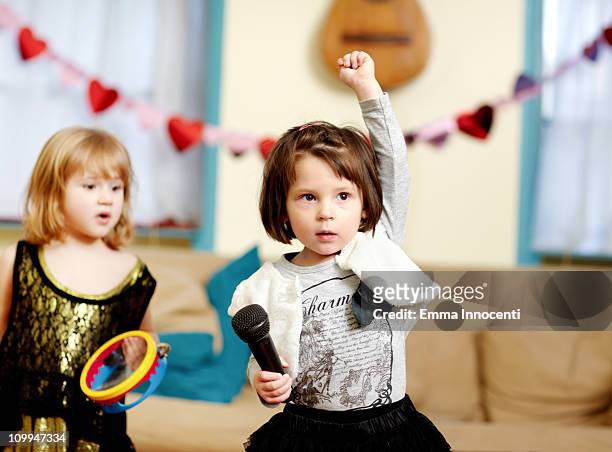 toddler, one arm raised, microphone, serious - pop music instruments stock pictures, royalty-free photos & images