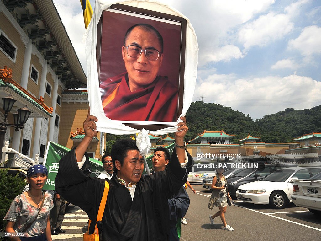 A Tibetan holds up high a portrait of Ti