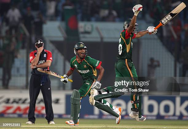 Shafiul Islam and Mahmudullah of Bangladesh celebrate scoring the winning runs as Andrew Strauss of England holds his head in his hands during the...