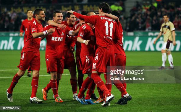 Milivoje Novakovic of Koeln celebrates with Lukas Podolski and other team mates after scoring his teams third goal during the Bundesliga match...