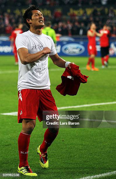 Tomoaki Makino of Koeln shows a shirt for the victims of the earthquake in his home country Japan after winning the Bundesliga match between 1. FC...