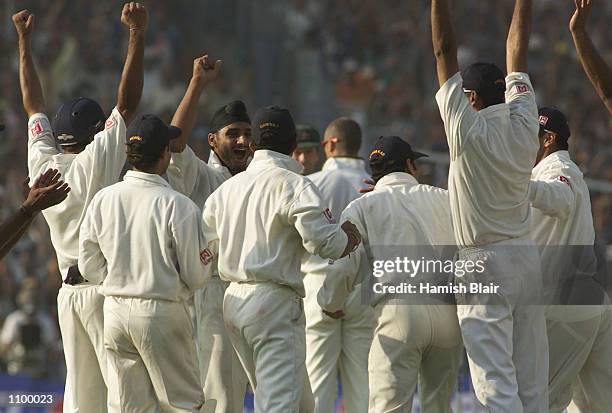 Harbhajan Singh of India celebrates with team mates after claiming the wicket of Shane Warne of Australia, to complete a hat trick, during day one of...