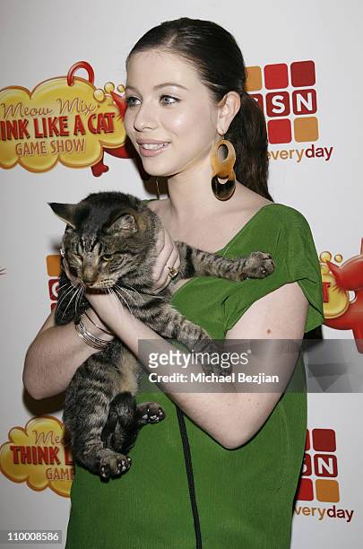 Actress Michelle Trachtenberg holds a cat as she arrives at the Meow Mix Think Like a Cat Game Show Premiere on November 12, 2008 in Los Angeles,...