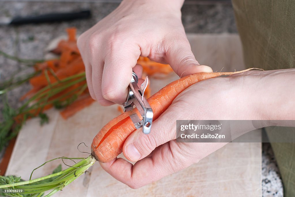 Young woman peeling carrots