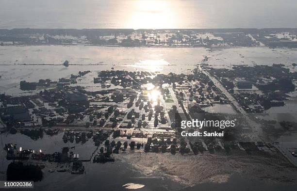 In this aerial image, a flooded Watari Town, caused by the tsunami is seen on March 12, 2011 in Watari, Fukushima, Japan. An earthquake measuring 8.9...