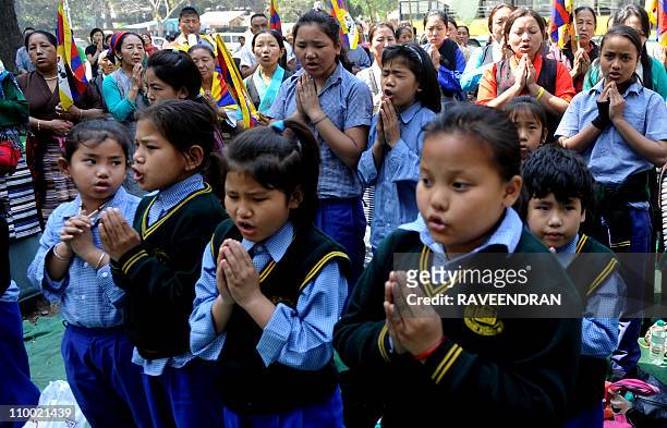 Tibetan women and schoolchildren pray as they pay homage to Tibetan martyrs who sacrificed their lives for the cause of Tibet, on the occasion of the...