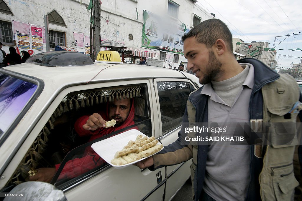 A Palestinian man distributes sweets in