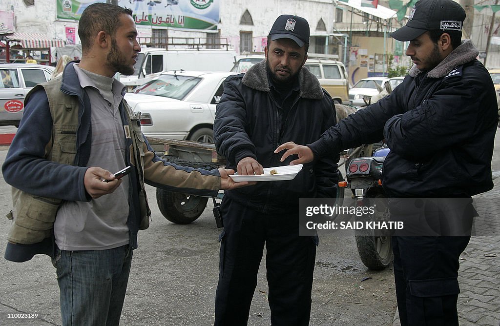 A Palestinian man offers sweets to Hamas