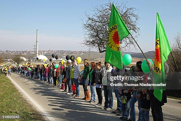 Anti-nuclear activists hold hands in a human chain they projected as 45km long in front of the Neckarwestheim nuclear power plant on March 12, 2011...