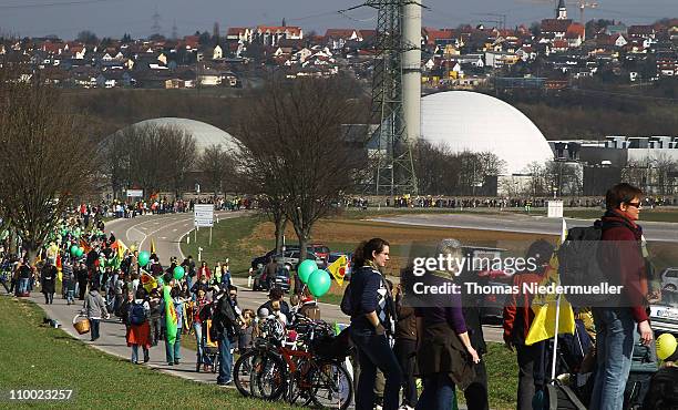 Anti-nuclear activists hold hands in a human chain they projected as 45km long in front of the Neckarwestheim nuclear power plant on March 12, 2011...