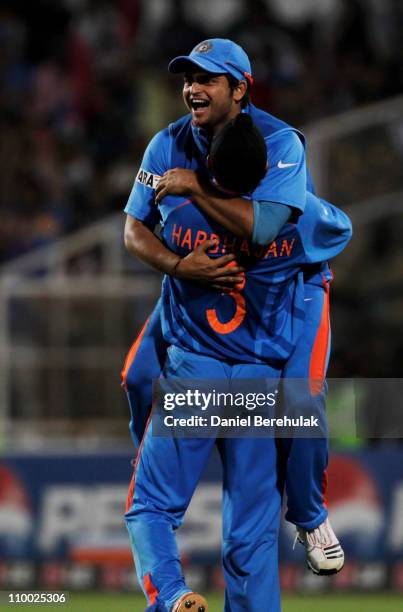 Substitute fieldsman Suresh Raina of India, celebrates with team mate Harbhajan Singh, after taking the catch to dismiss Johan Both of South Africa...