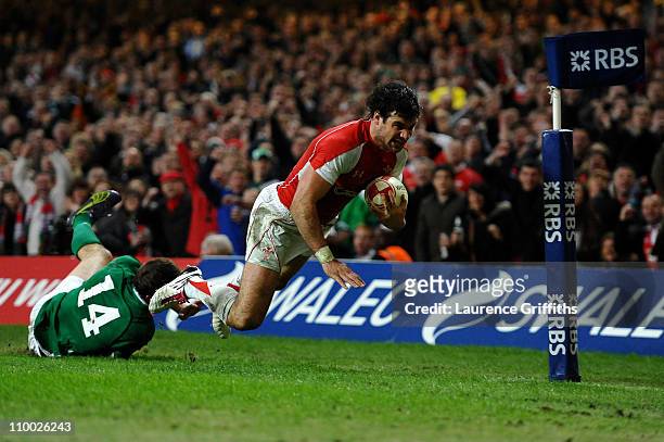 Mike Phillips of Wales dives past the challenge from Tommy Bowe of Ireland to score a try during the RBS Six Nations Championship match between Wales...