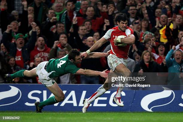 Mike Phillips of Wales hands off Tommy Bowe of Ireland to score a try during the RBS Six Nations Championship match between Wales and Ireland at the...