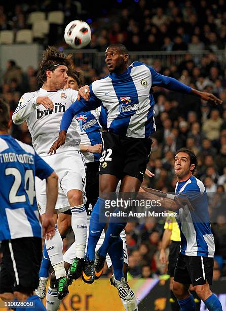 Sergio Ramos of Real Madrid jumps for a high ball with Olivier Thomert of Hercules during the La Liga match between Real Madrid and Hercules at...