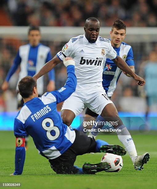 Lass Diarra of Real Madrid takes on ;Francisco Farinos of Hercules CF during the La Liga match between Real Madrid and Hercules CF at Estadio...