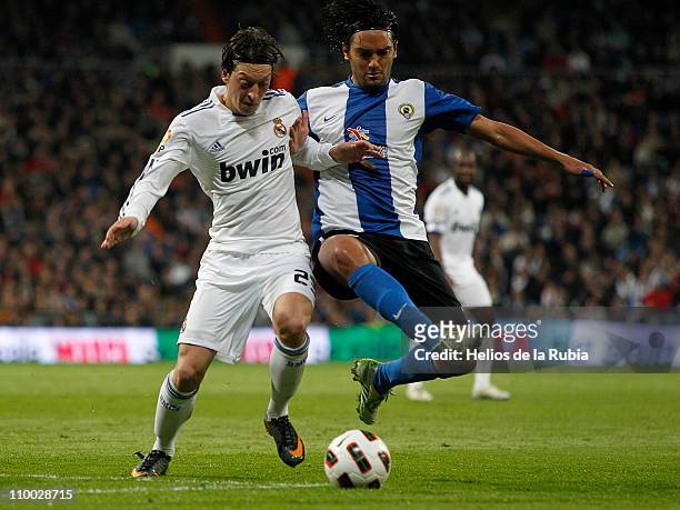 Mesut Ozil of Real Madrid duels for the ball with Abel Aguilar of Hercules during the La Liga match between Real Madrid and Hercules at Estadio...