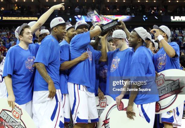 Markieff Morris of the Kansas Jayhawks holds the championship trophy as he celebrates with teammates after defeating the Texas Longhorns 85-73 to win...