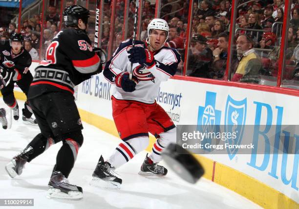 Chad LaRose of the Carolina Hurricanes defends Sami Lepisto of the Columbus Blue Jackets as he shoots the puck during an NHL game on March 12, 2011...
