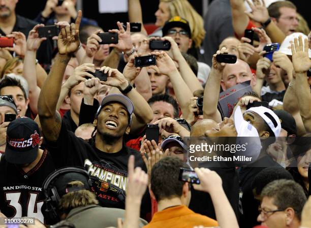 Kawhi Leonard and Billy White of the San Diego State Aztecs celebrate with fans after the team's 72-54 victory over the Brigham Young University...