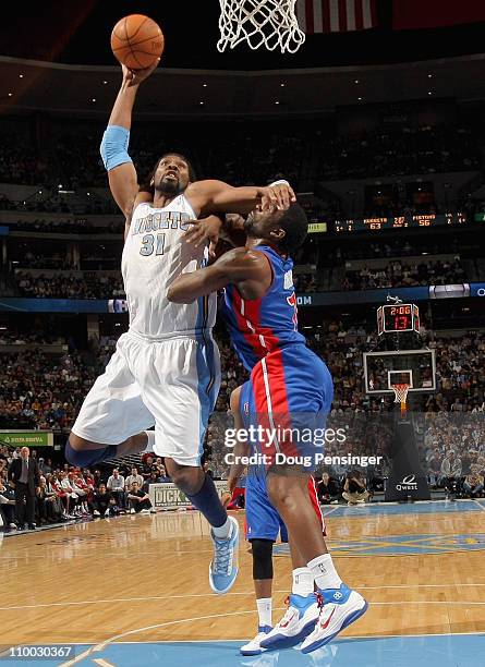Nene of the Denver Nuggets is fouled by Ben Gordon of the Detroit Pistons as he goes to the basket at the Pepsi Center on March 12, 2011 in Denver,...