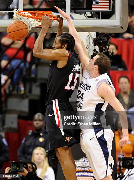 Kawhi Leonard of the San Diego State Aztecs dunks in front of Noah Hartsock of the Brigham Young University Cougars during the championship game of...