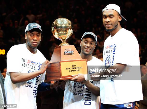 Donnell Beverly, Kemba Walker and Charles Okwandu of the Connecticut Huskies hold up the Championship trophy after defeating the Louisville Cardinals...