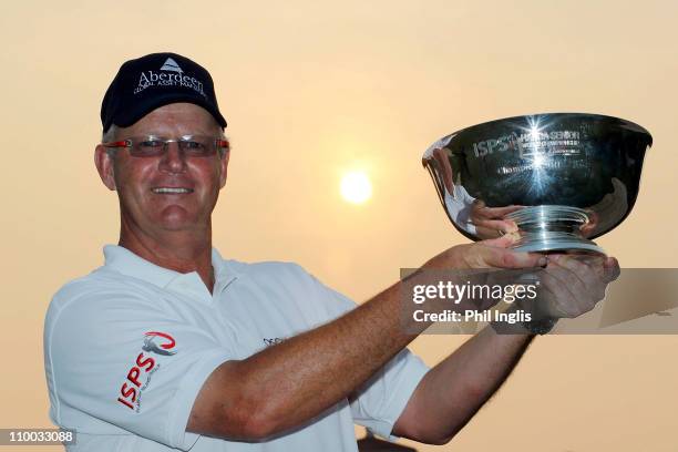 Sandy Lyle of Scotland poses with the trophy after the final round of the ISPS Handa Senior World Championship presented by Mission Hills China and...