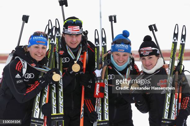Magdalena Neuner of Germany and her team mates Tina Bachmann , Miriam Goessner and Andrea Henkel poses with their goild medals at the victory...