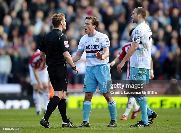 Referee Mike Jones is confronted by Scott Parker and Matthew Upson of West Ham United after the second Stoke City goal during the FA Cup sponsored by...