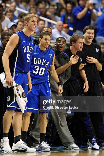 Mason Plumlee, Seth Curry and Kyrie Irving of the Duke Blue Devils cheer from the bench while playing the North Carolina Tar Heels during the first...