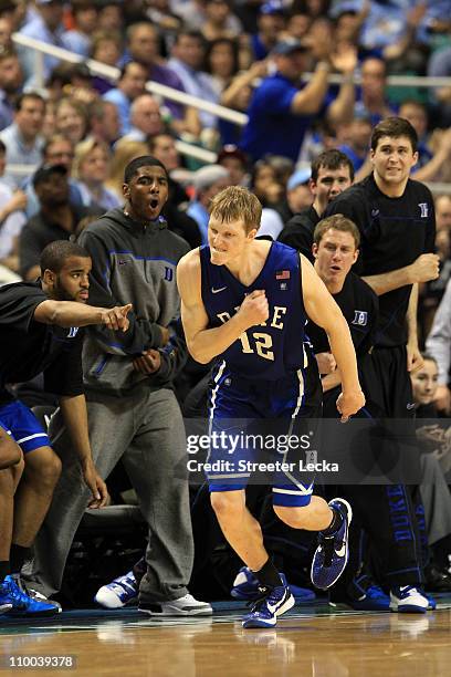 Kyle Singler of the Duke Blue Devils reacts as teammate Kyrie Irving and the bench cheer him on during the second half of the game against the North...