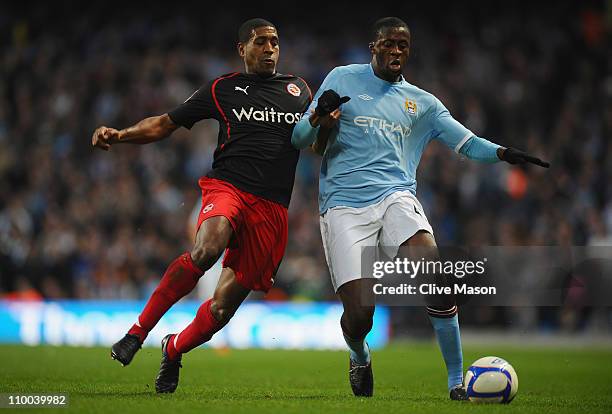 Mikele Leigertwood of Reading and Yaya Toure of Manchester City battle for the ball during the FA Cup sponsored by E.On Sixth Round match between...
