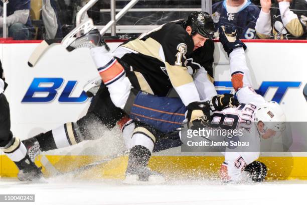Michael Rupp of the Pittsburgh Penguins finishes a check on Jeff Petry of the Edmonton Oilers on March 13, 2011 at CONSOL Energy Center in...