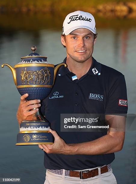 Nick Watney poses with the Gene Sarazen trophy after his two-stroke victory at the 2011 WGC- Cadillac Championship at the TPC Blue Monster at the...
