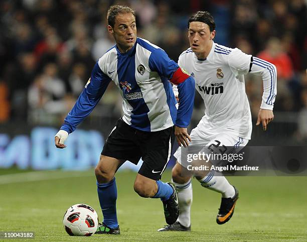 Francisco Farinos of Hercules is chased by Mesut Ozil of Real Madrid during the La Liga match between Real Madrid and Hercules at Estadio Santiago...