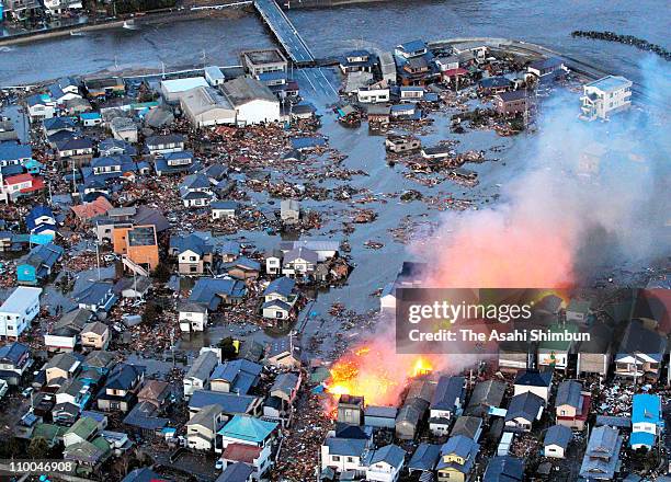 In this aerial image, a fire caused by tsunami is seen in the flooding Iwaki City after a 9.0 magnitude strong earthquake struck off the coast of...