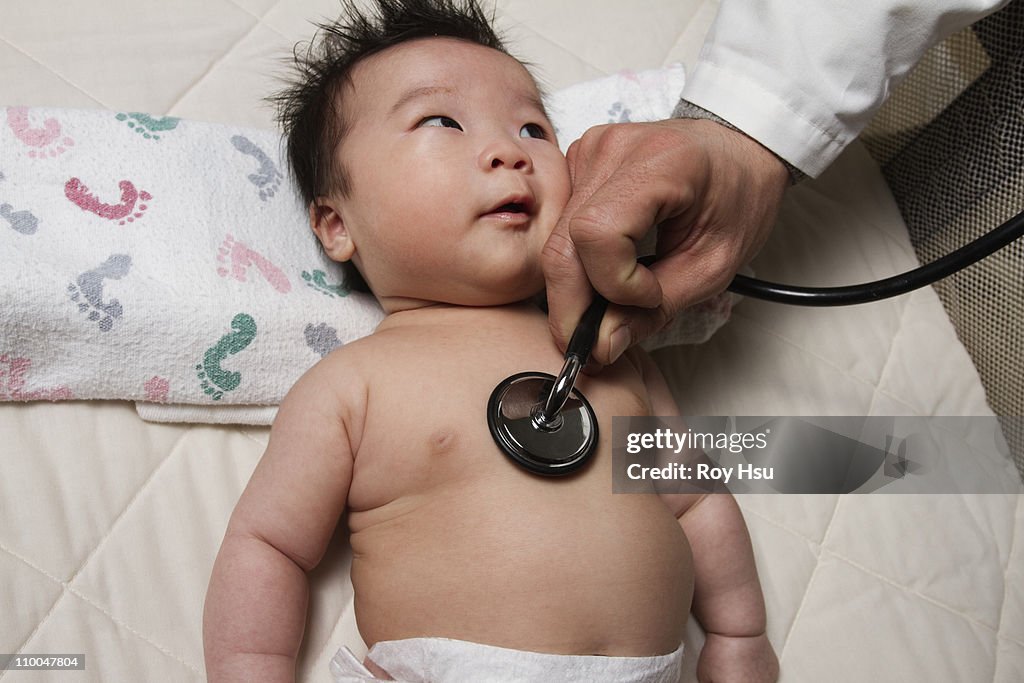 Doctor with stethoscope and new born Chinese girl