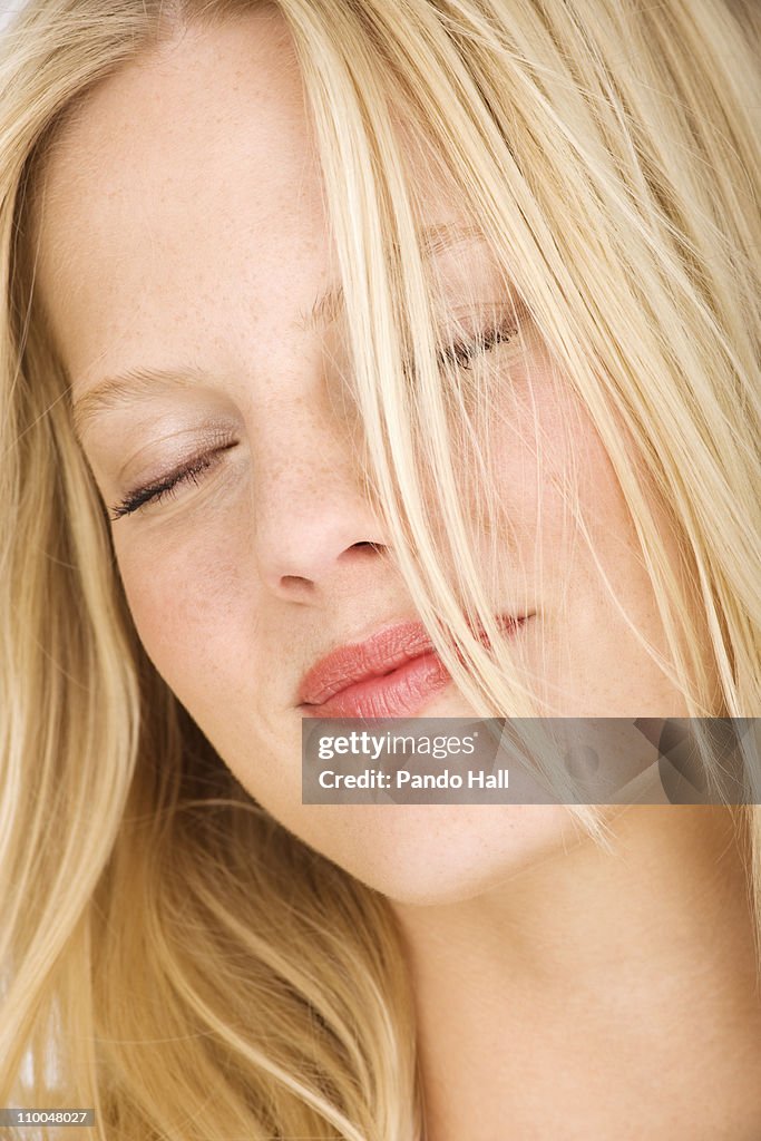 Young woman with eyes closed smiling, close-up