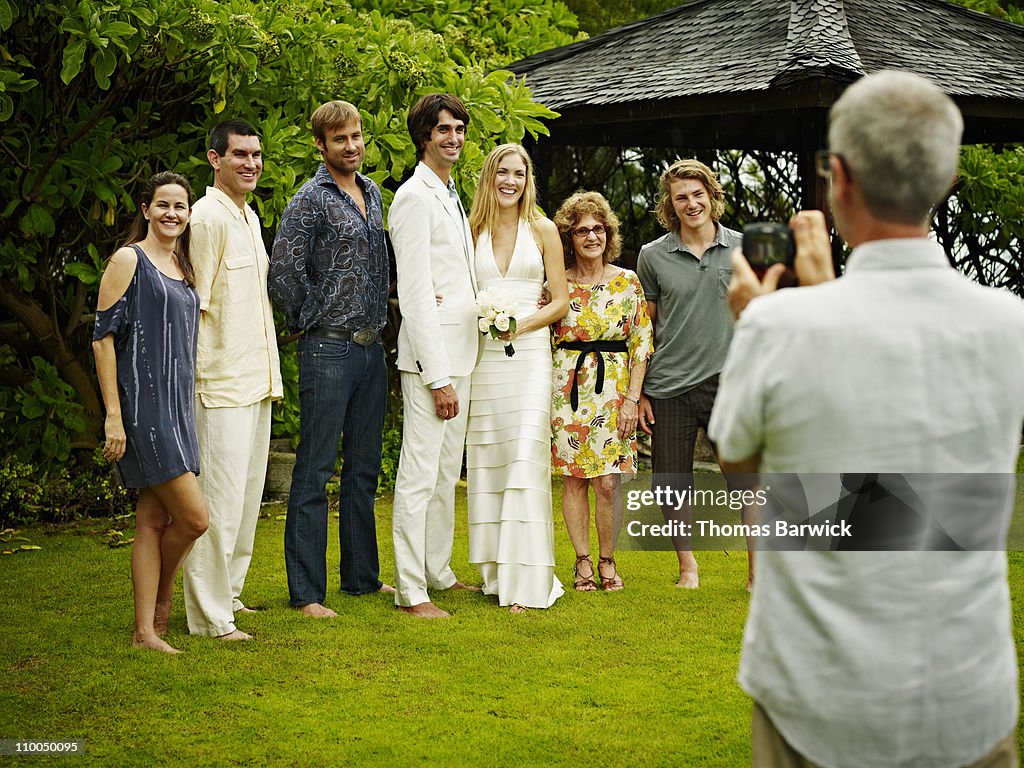 Father taking digital photo of bridal party