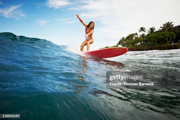 female surfer riding wave view from water - surfer stock pictures, royalty-free photos & images
