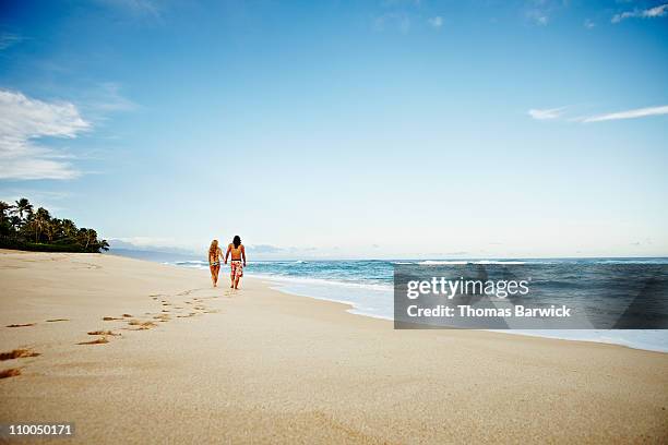 husband and wife walking down empty tropical beach - hawaii beach stock pictures, royalty-free photos & images