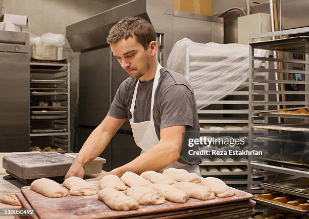 baker preparing bread - bäcker stock-fotos und bilder