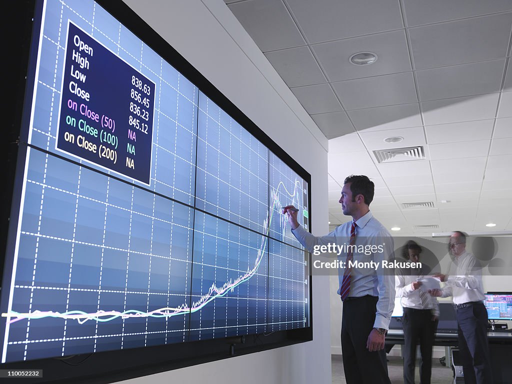 Businessman using graphs on screen